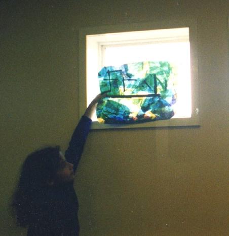 Worton Road Community Centre, Environmental Theme  Mural project, Isleworth, 1997.. Another co-production for and by the community, via Making Murals. Isabella's daughter, Francesca Demetriou, holds her work up to the light!